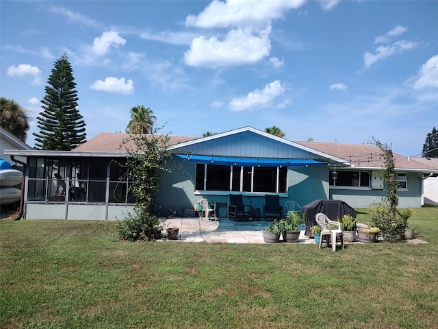 back of house featuring a patio, a lawn, and a sunroom