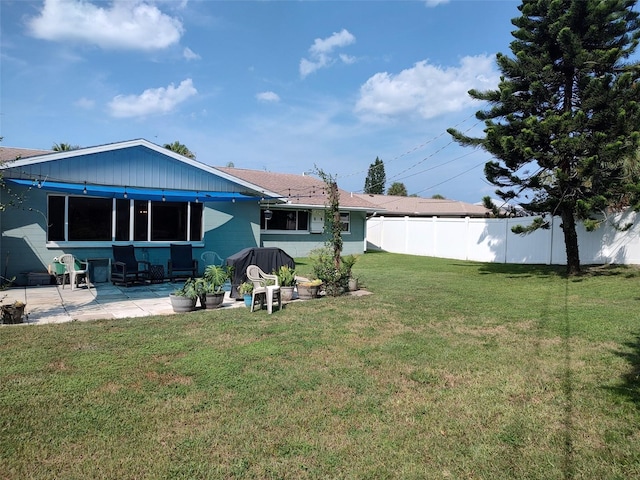 back of property with a lawn and a patio area