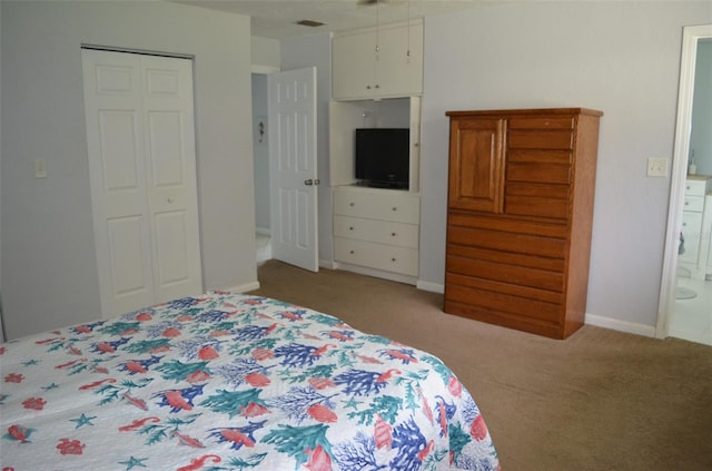 bedroom featuring light carpet, ensuite bath, and a closet