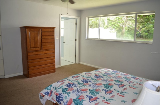 bedroom with multiple windows, ceiling fan, and light colored carpet