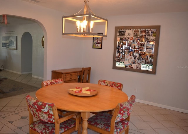 tiled dining room featuring a chandelier