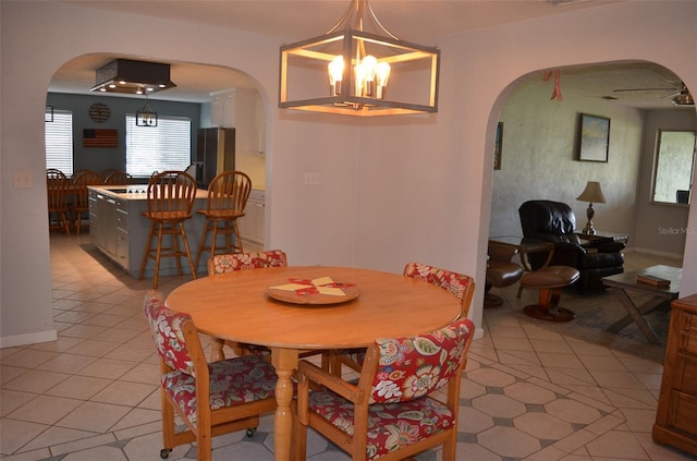 tiled dining room featuring a chandelier