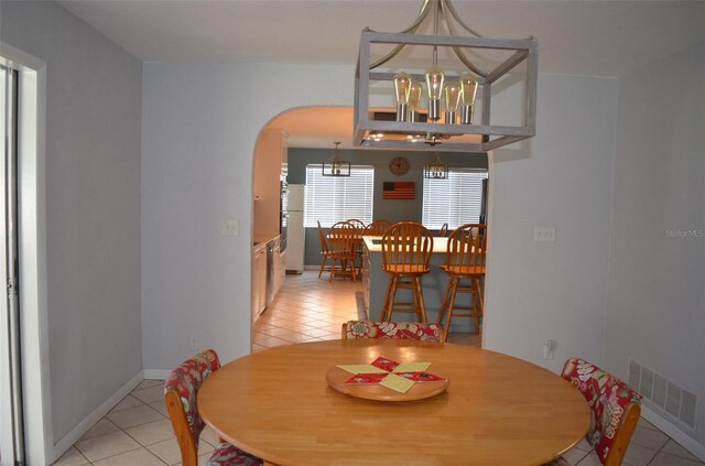 dining area with a chandelier and light tile patterned floors