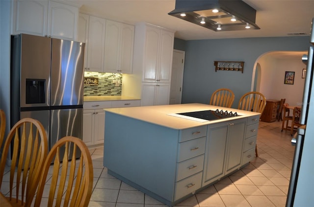 kitchen with white stovetop, white cabinets, stainless steel fridge with ice dispenser, and a kitchen island