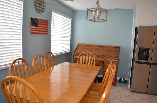 tiled dining area with a notable chandelier