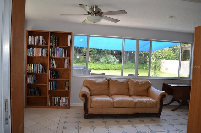 living room with ceiling fan and a textured ceiling