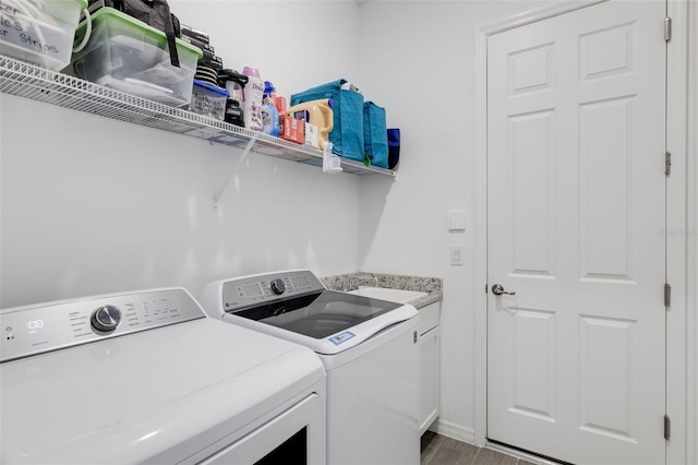 laundry area with cabinets, light wood-type flooring, sink, and washing machine and clothes dryer