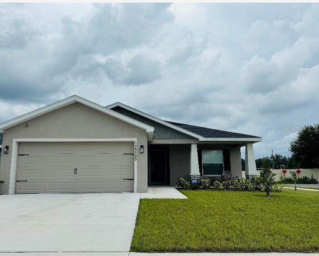 view of front of property featuring a garage and a front lawn