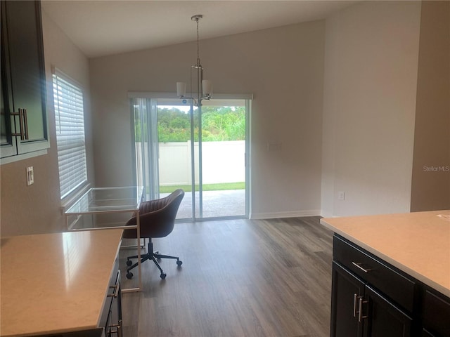 office with light hardwood / wood-style floors, vaulted ceiling, and an inviting chandelier