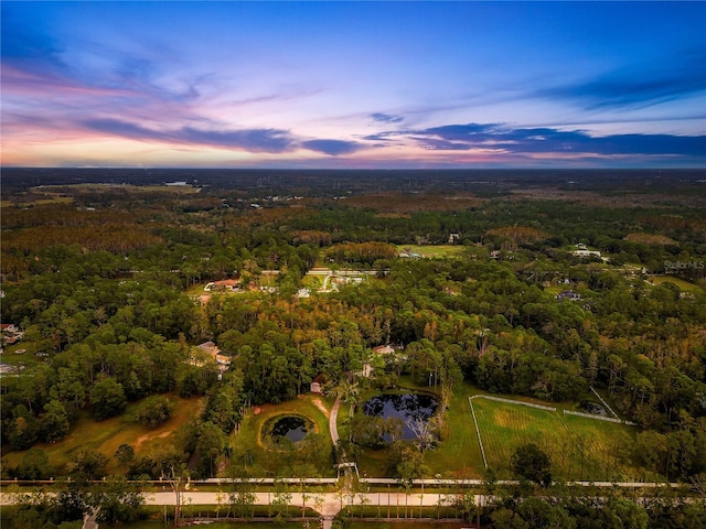 aerial view at dusk featuring a water view