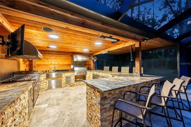 view of patio / terrace with a grill, an outdoor kitchen, and a wet bar