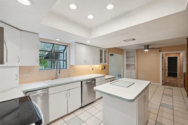 kitchen featuring dishwasher, sink, a kitchen island, a raised ceiling, and white cabinets