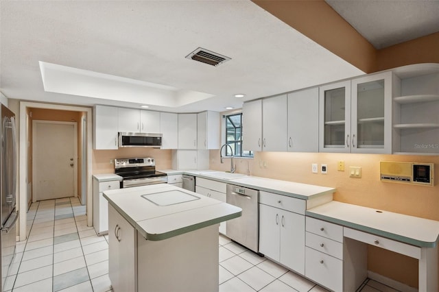 kitchen featuring white cabinetry, sink, a center island, stainless steel appliances, and light tile patterned floors