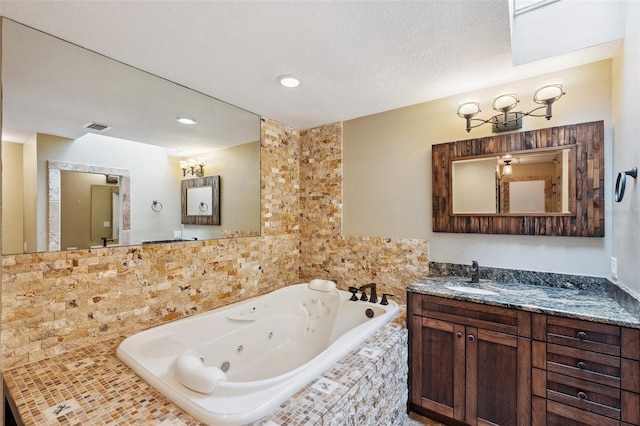 bathroom with vanity and tiled tub