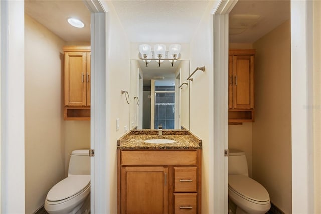 bathroom featuring vanity, toilet, and a textured ceiling