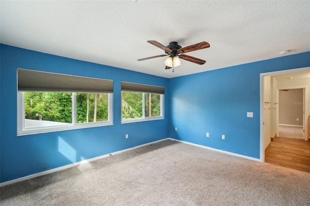 unfurnished room with ceiling fan, carpet floors, and a textured ceiling