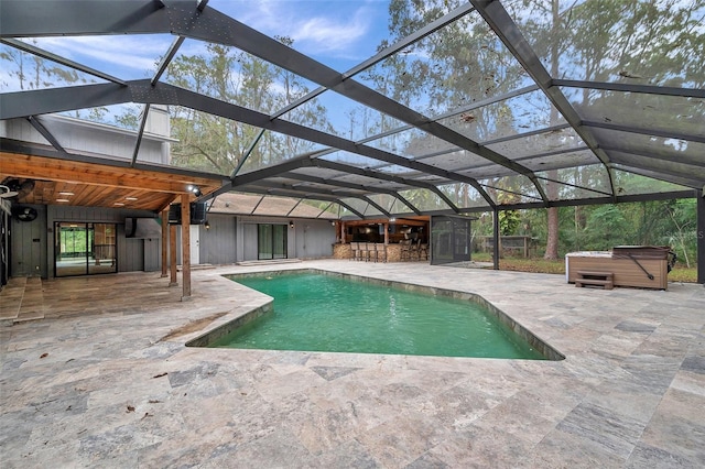 view of pool featuring a lanai, exterior bar, a patio, and a hot tub