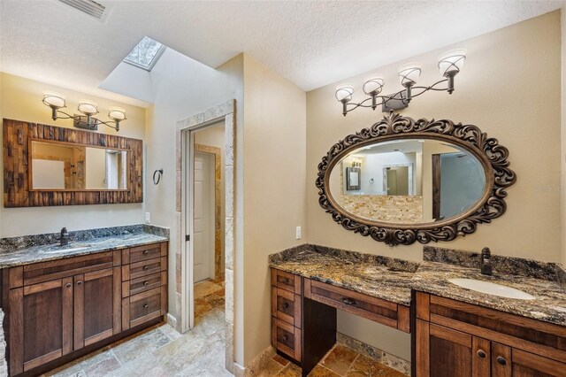 bathroom featuring vanity, a textured ceiling, and a skylight