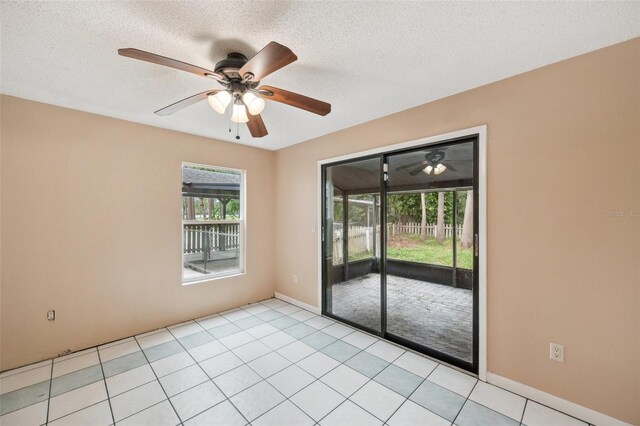 tiled empty room with a textured ceiling