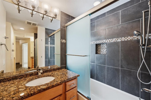 bathroom with vanity and shower / bath combination with glass door