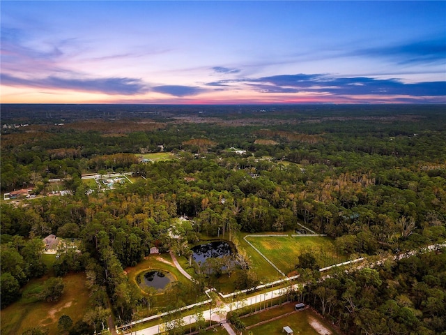 aerial view at dusk featuring a water view