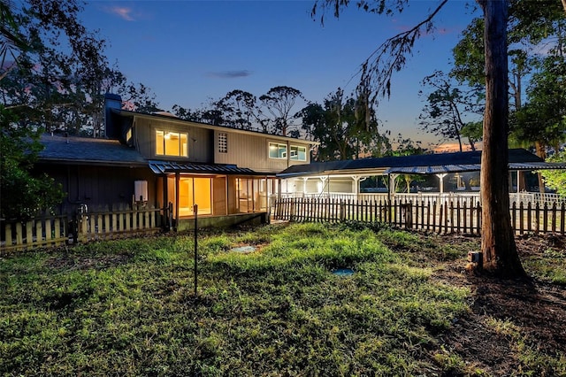 back house at dusk featuring a garage