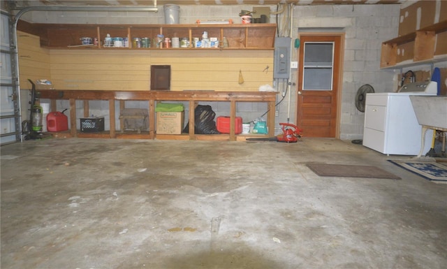 garage featuring electric panel and washer / dryer