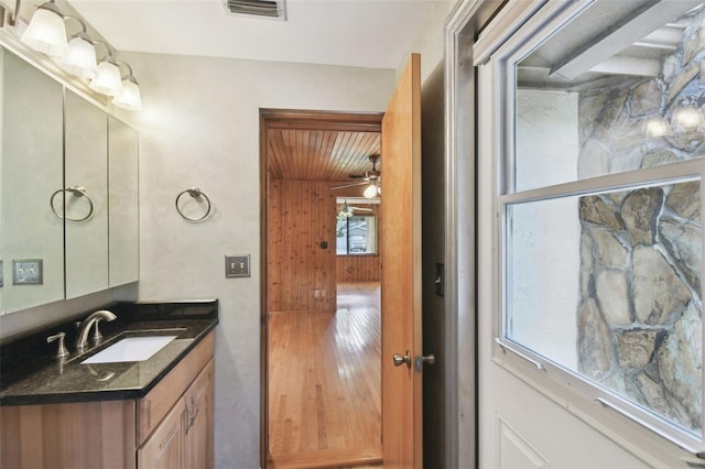 bathroom with wood-type flooring, vanity, and ceiling fan