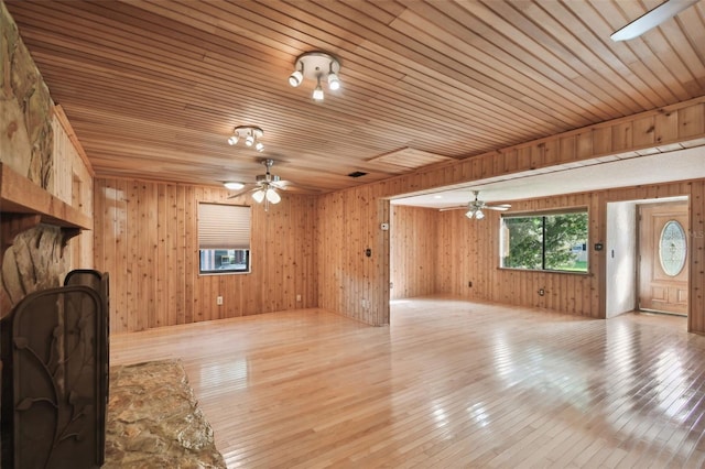 living room featuring wooden walls, ceiling fan, wood ceiling, and light wood-type flooring