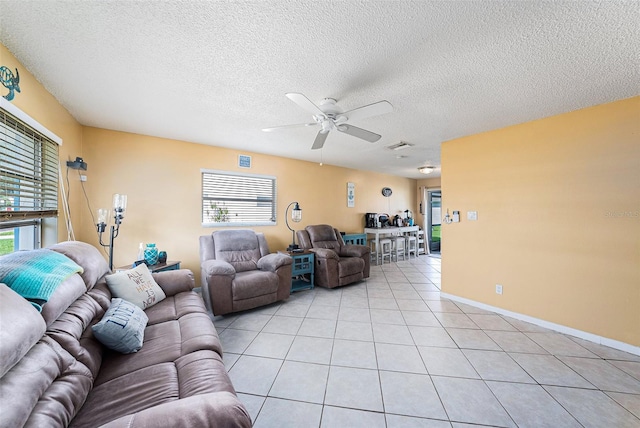 living room featuring a textured ceiling, visible vents, a ceiling fan, and light tile patterned floors