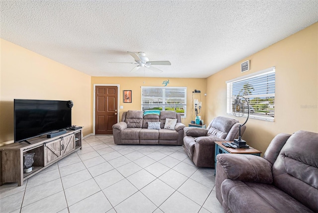 tiled living room with a textured ceiling and ceiling fan