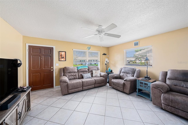 living room with a textured ceiling, ceiling fan, and light tile patterned floors