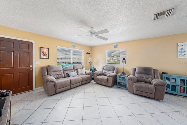 living room with a textured ceiling, light tile patterned floors, and ceiling fan