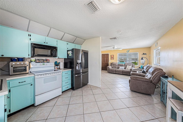 kitchen featuring visible vents, stainless steel fridge, white electric range, black microwave, and blue cabinets