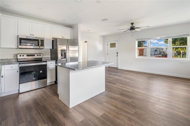 kitchen featuring stainless steel appliances, white cabinets, ceiling fan, and a center island