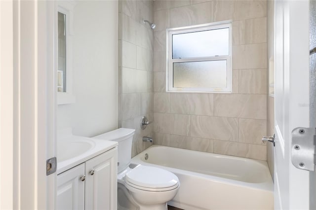 full bathroom with tiled shower / bath combo, vanity, and toilet