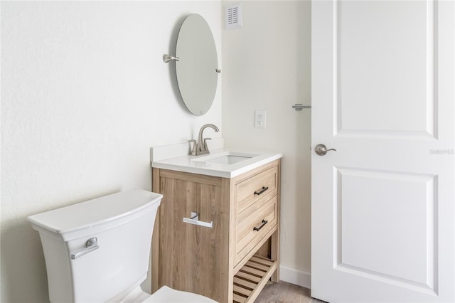 bathroom featuring hardwood / wood-style flooring, vanity, and toilet