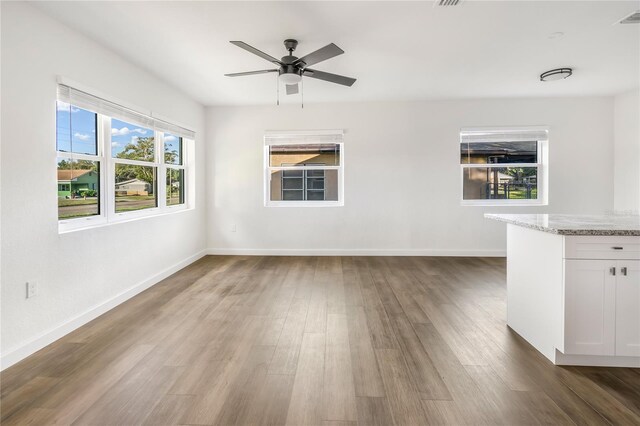 interior space with bar area, ceiling fan, and dark wood-type flooring