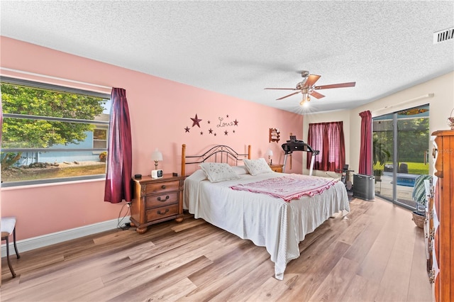 bedroom featuring a textured ceiling, light wood-type flooring, access to outside, and ceiling fan