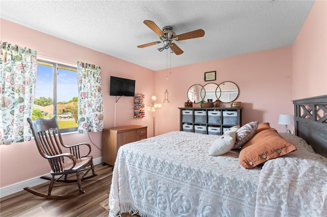 bedroom with ceiling fan, a textured ceiling, and hardwood / wood-style flooring