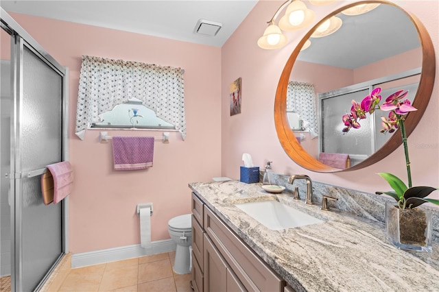 bathroom featuring tile patterned flooring, vanity, toilet, and a shower with shower door