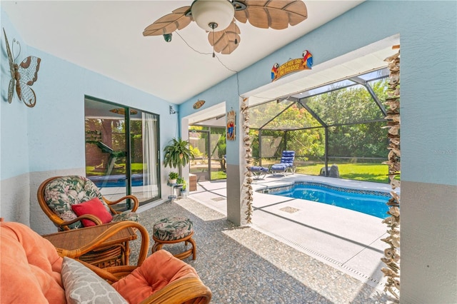 view of swimming pool with glass enclosure, ceiling fan, and a patio area