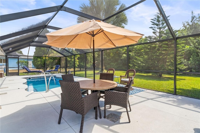 view of pool featuring a lawn, a patio area, and glass enclosure