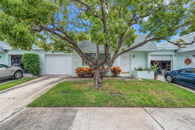 view of front of home with a front yard and a garage