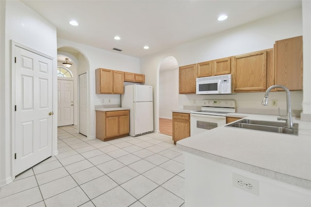 kitchen with light tile patterned floors, sink, and white appliances