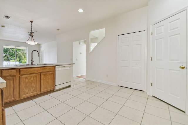 kitchen featuring pendant lighting, dishwasher, light tile patterned floors, and sink