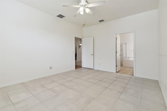 unfurnished bedroom with ceiling fan, light tile patterned floors, and ensuite bathroom