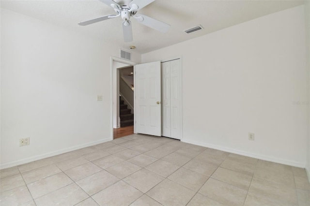 unfurnished bedroom featuring light tile patterned floors, ceiling fan, and a closet