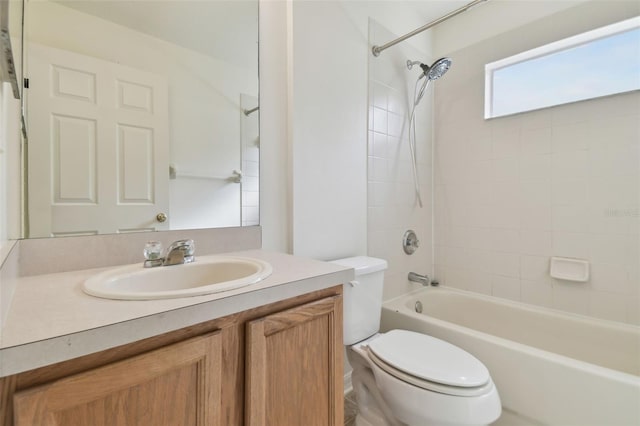 full bathroom with tiled shower / bath, vanity, and toilet