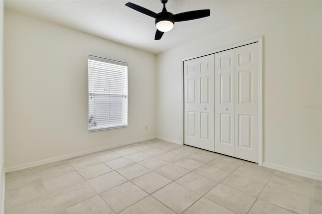 unfurnished bedroom featuring a closet, ceiling fan, and light tile patterned floors